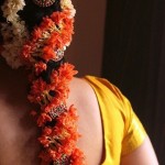 Braided hairstyle with a bun and real twisted floral garlands